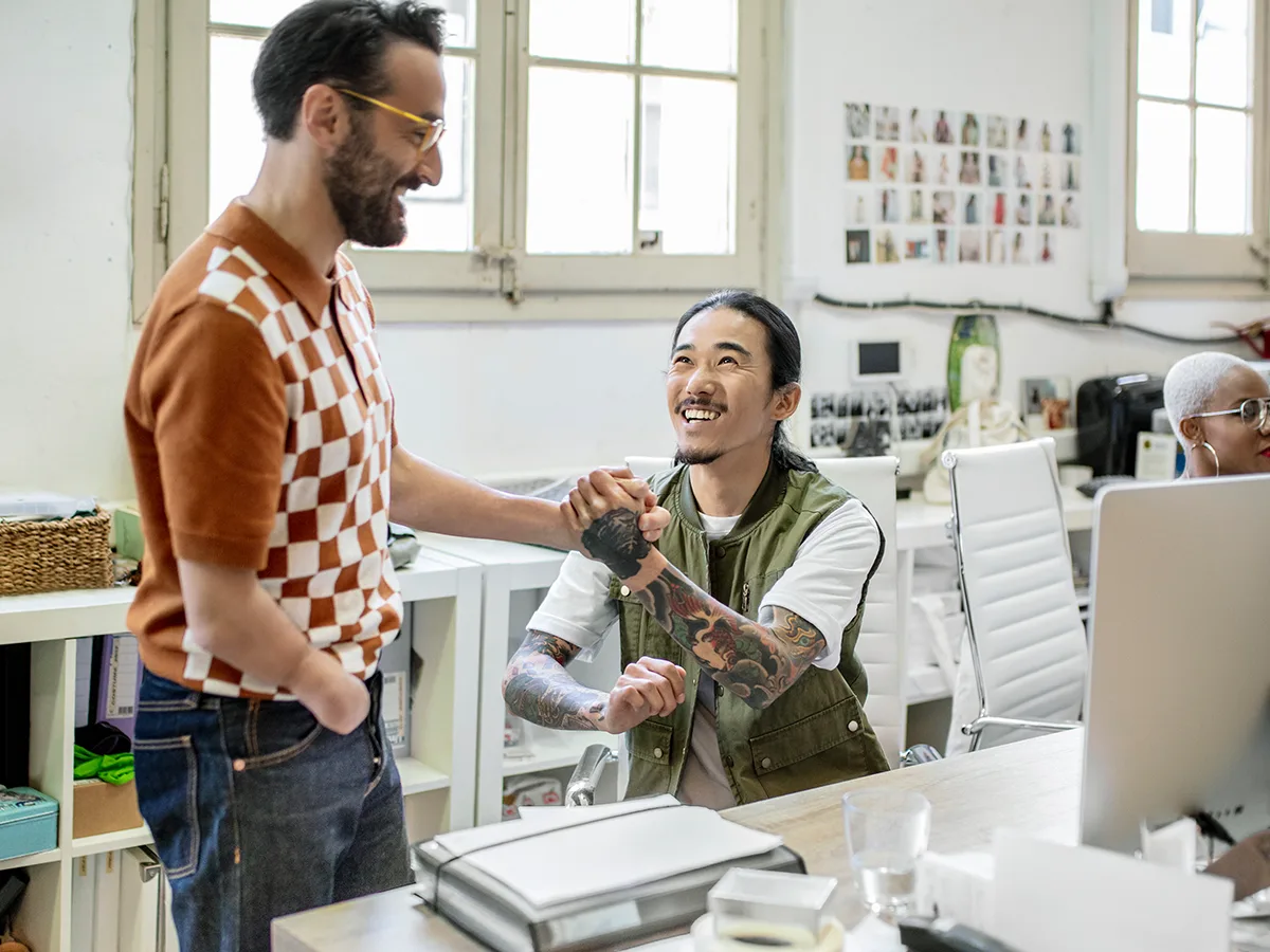 What is an inclusive workplace?, coworkers shaking hands at work